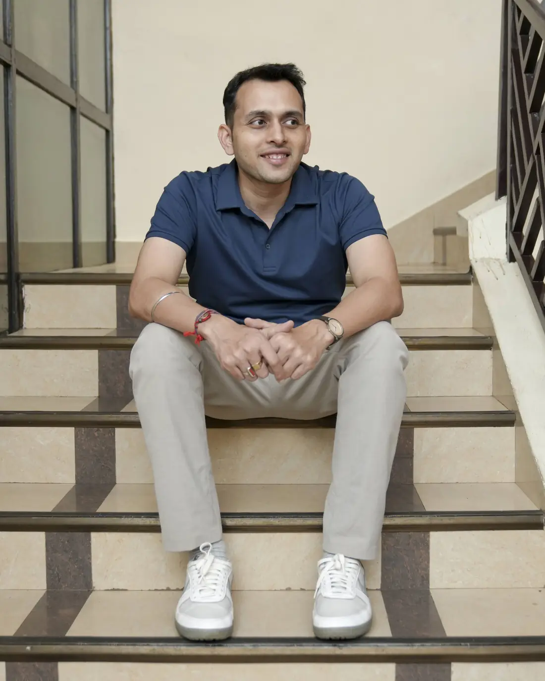 Sagar Sangam Sahu sitting on a staircase, smiling